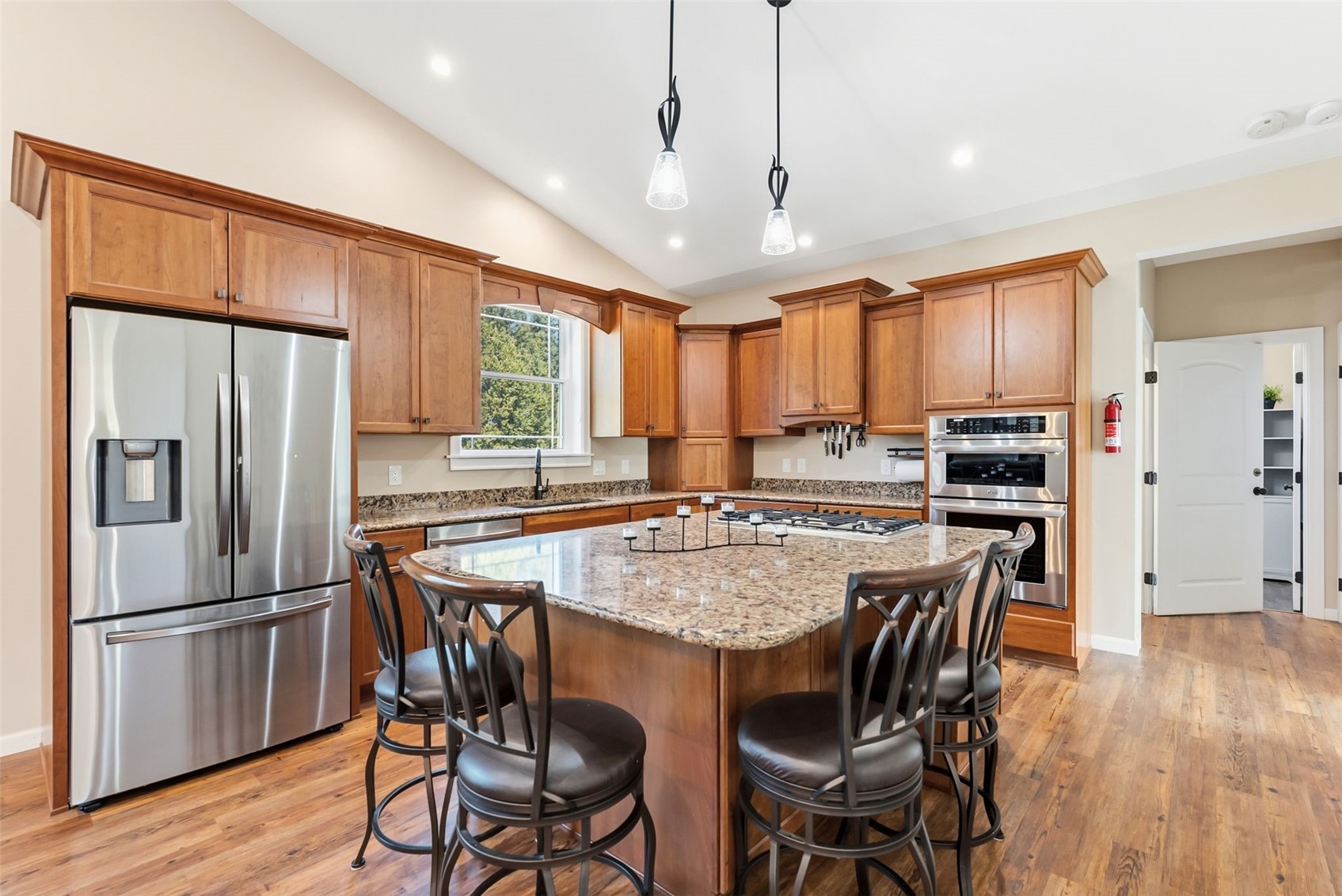 1227 Edgewood Road Alma, CO 80420 - Photo 22 of 40 a kitchen with stainless steel appliances granite countertop a stove a refrigerator a oven a sink a dining table and chairs with wooden floor