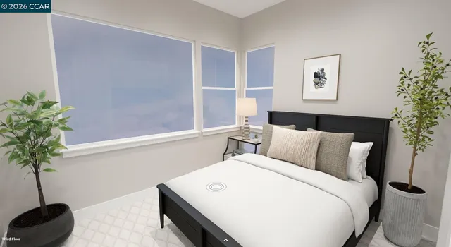 a bedroom with a large bed and a potted plant