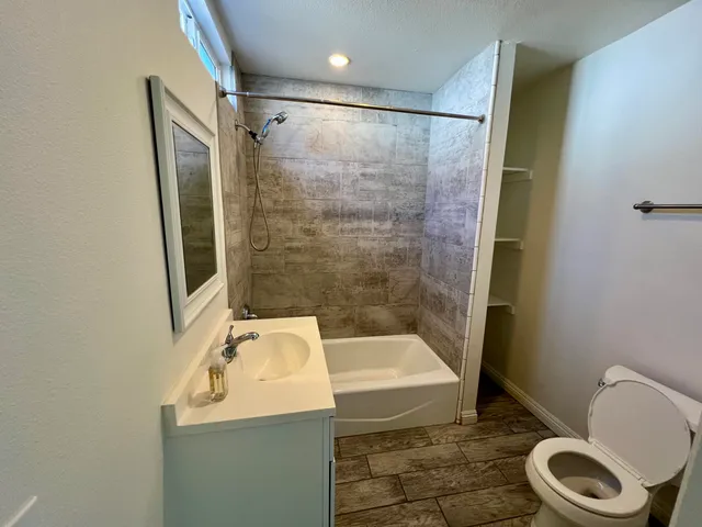 a bathroom with a sink a toilet and shower