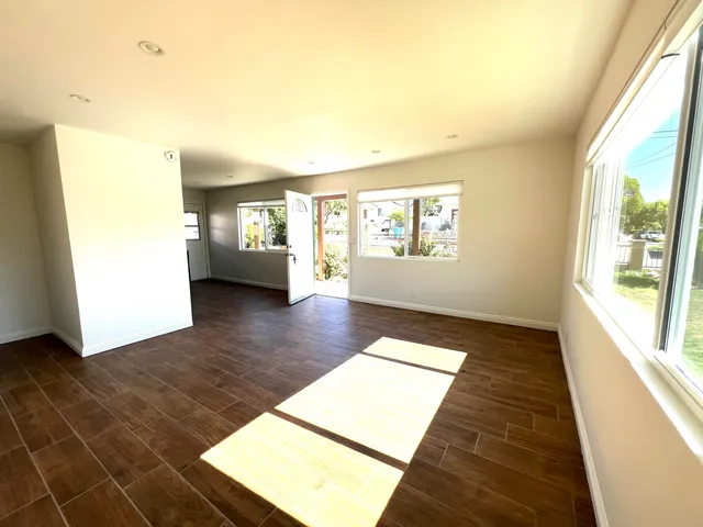 a view of a hallway with wooden floor and windows