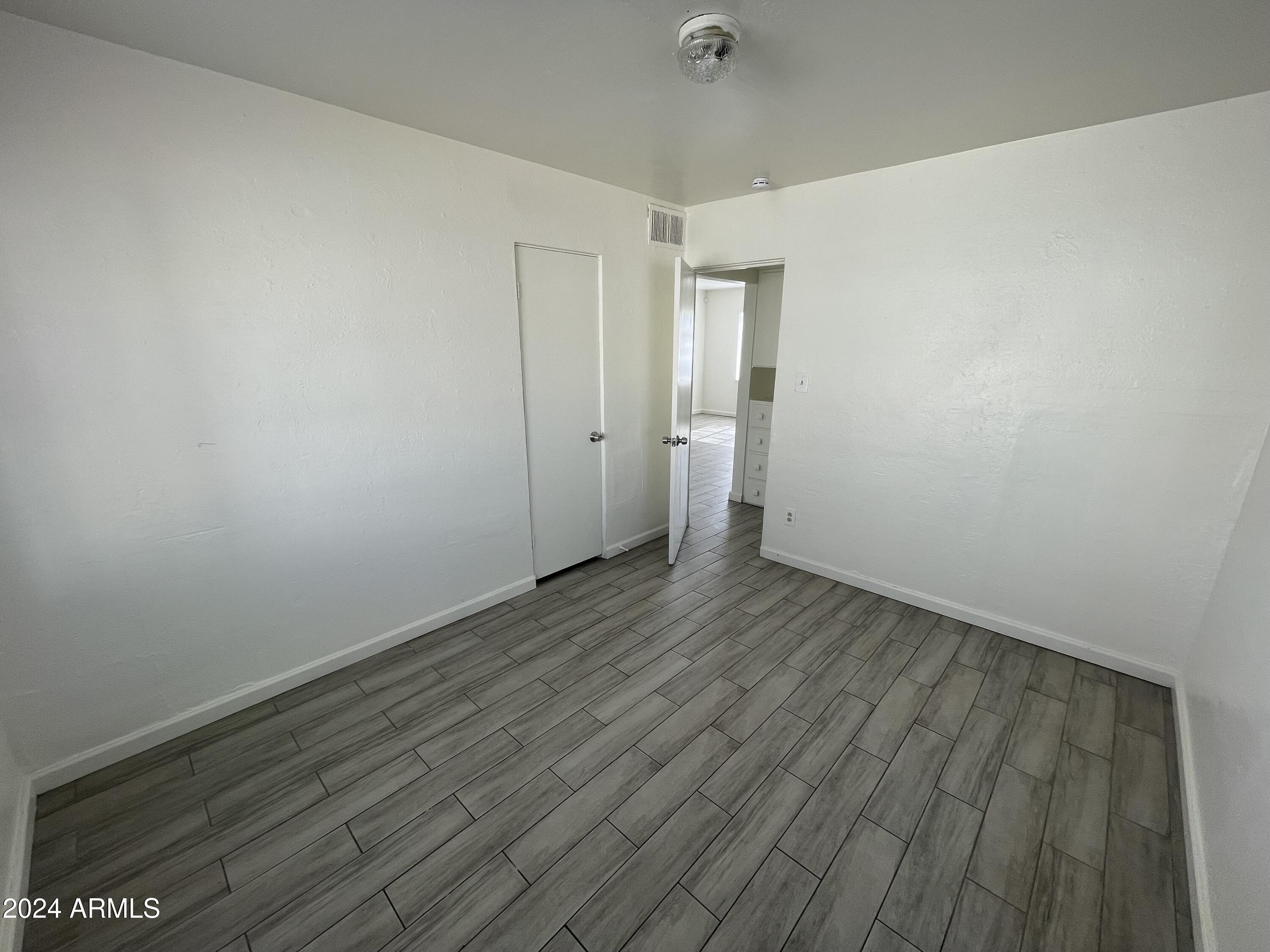 7210 North 55th Drive Glendale, AZ 85301 - Photo 6 of 13 a view of an empty room with wooden floor