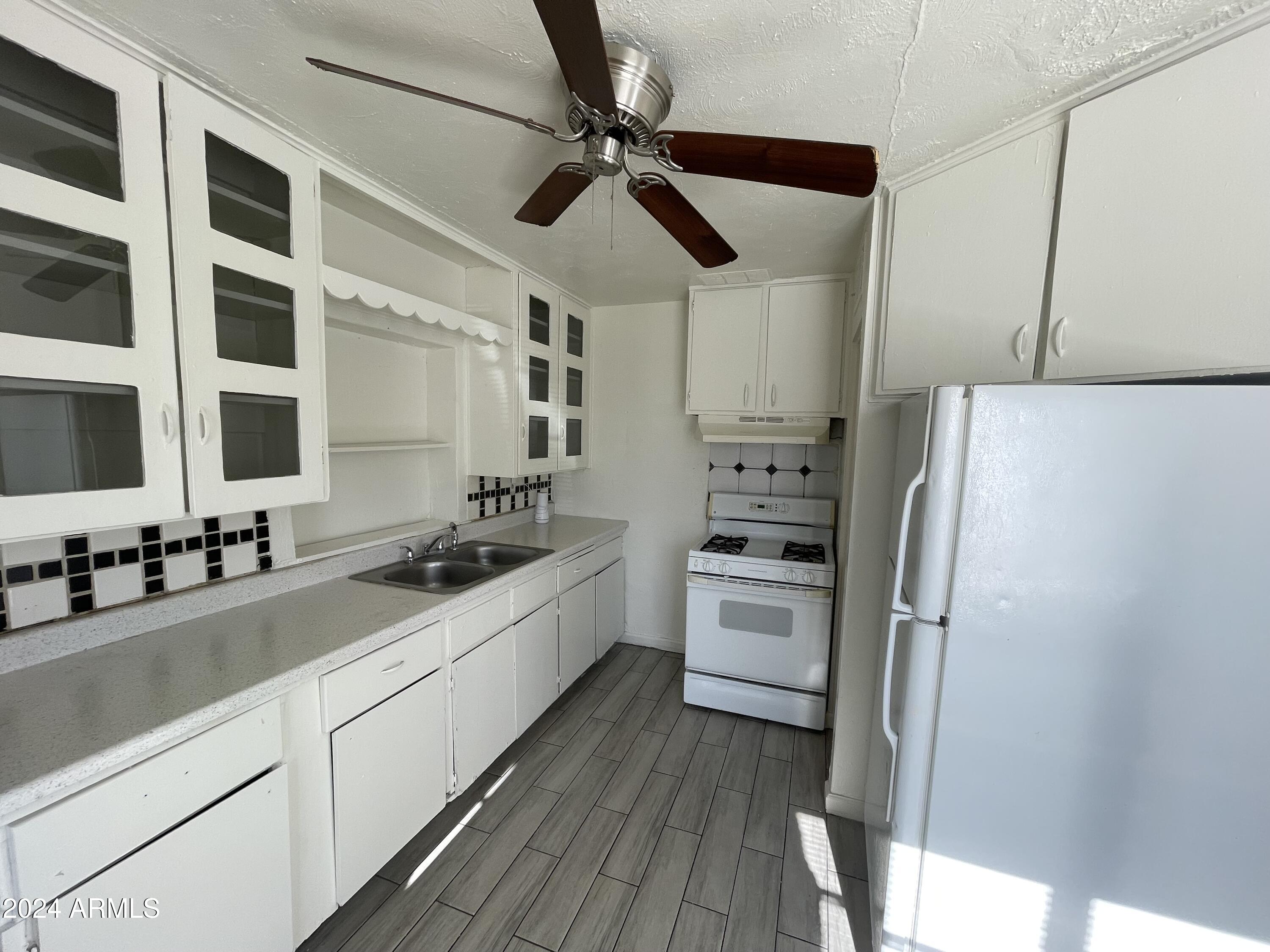 7210 North 55th Drive Glendale, AZ 85301 - Photo 9 of 13 a kitchen with stainless steel appliances a sink a stove a refrigerator and cabinets