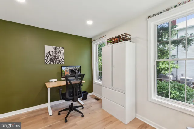 a view of a workspace with furniture and a window