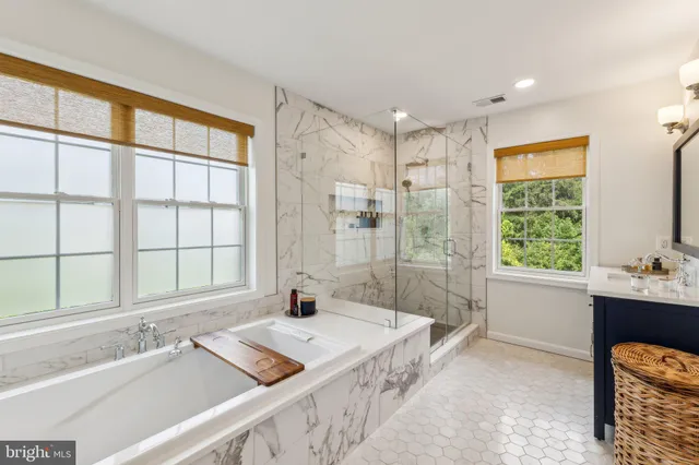 a spacious bathroom with a tub sink and mirror
