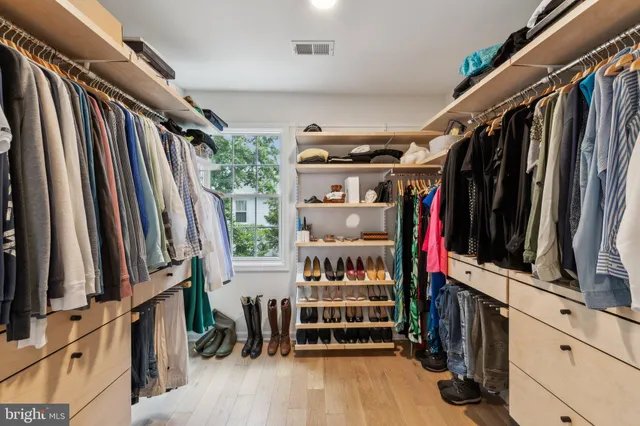 a view of walk in closet with clothes and shoes