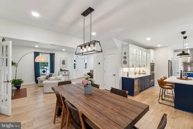 a view of a dining room and livingroom with furniture wooden floor a chandelier