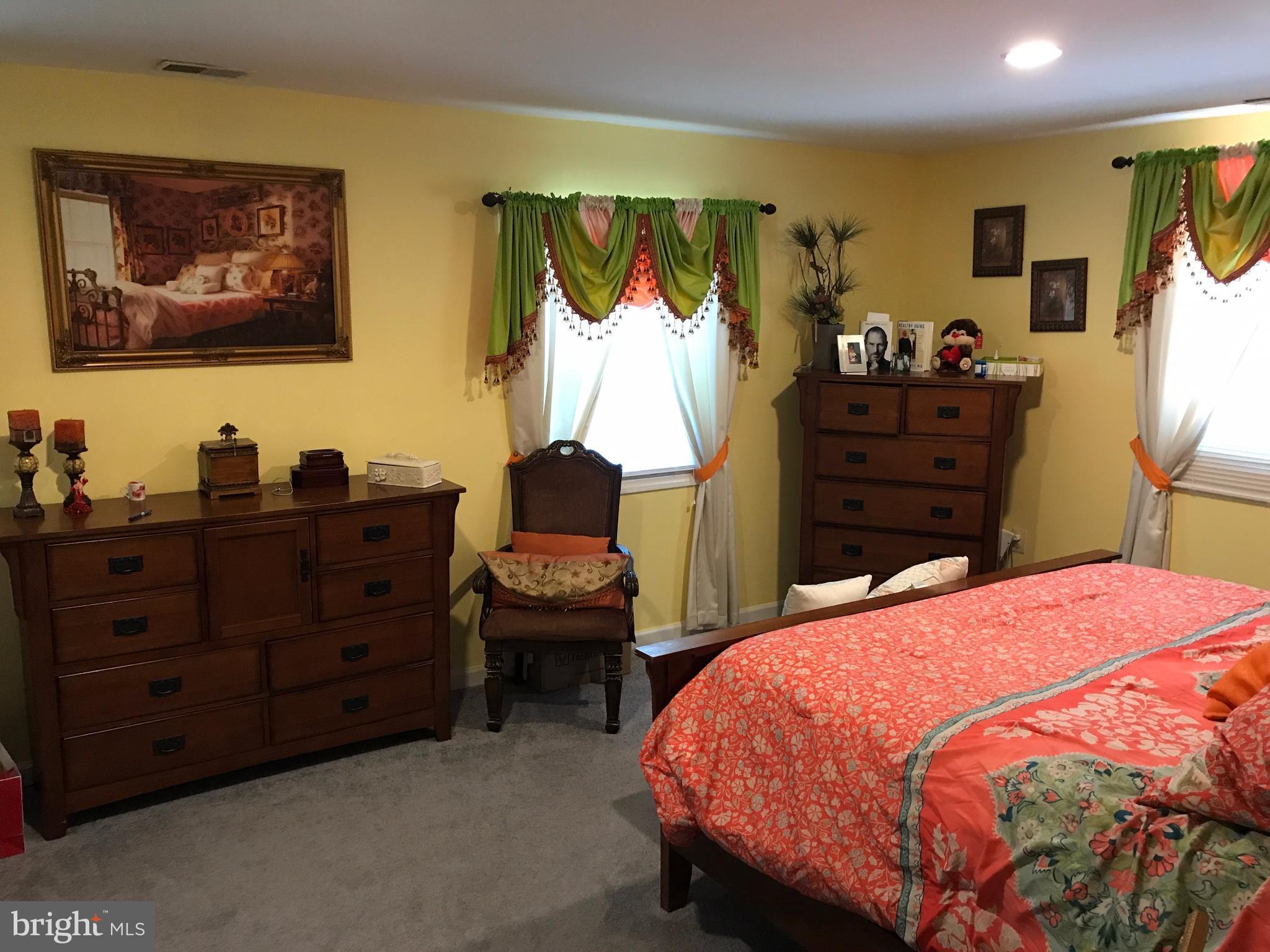 2714 Hughes Road Adelphi, MD 20783 - Photo 3 of 15 a bedroom with a bed and dresser with mirror