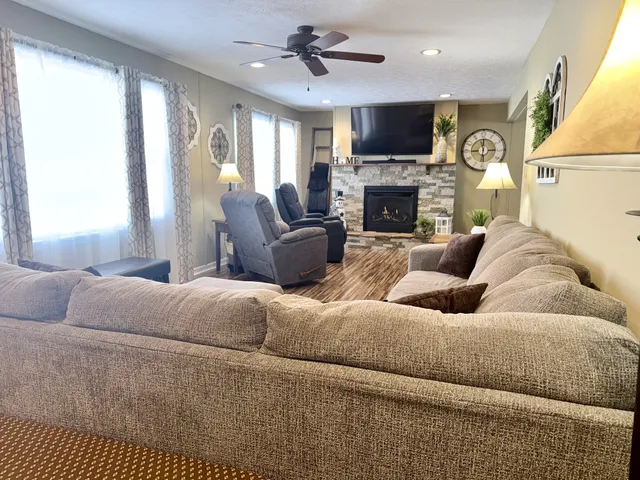 a living room with furniture a flat screen tv and a fireplace