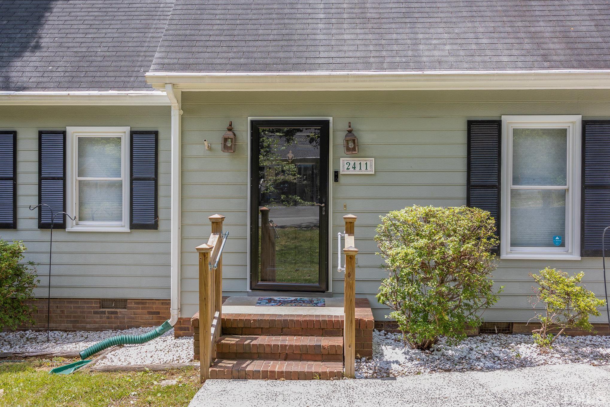 2411 Wade Hampton Road Hillsborough, NC 27278 - Photo 2 of 21 a front view of a house with garden