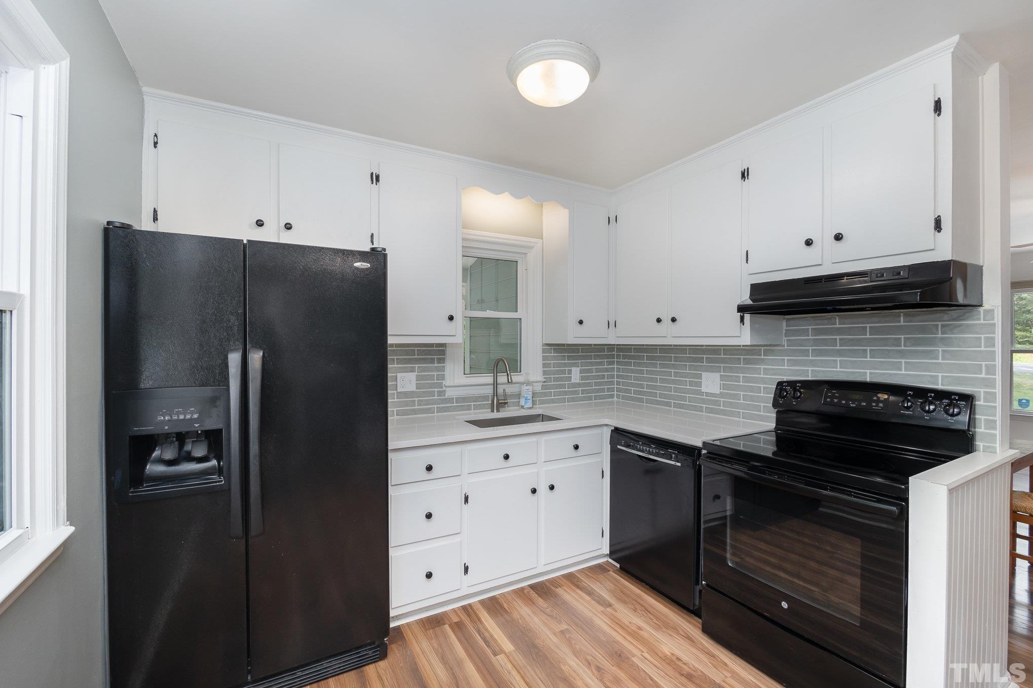 2411 Wade Hampton Road Hillsborough, NC 27278 - Photo 6 of 21 a kitchen with granite countertop white cabinets and refrigerator