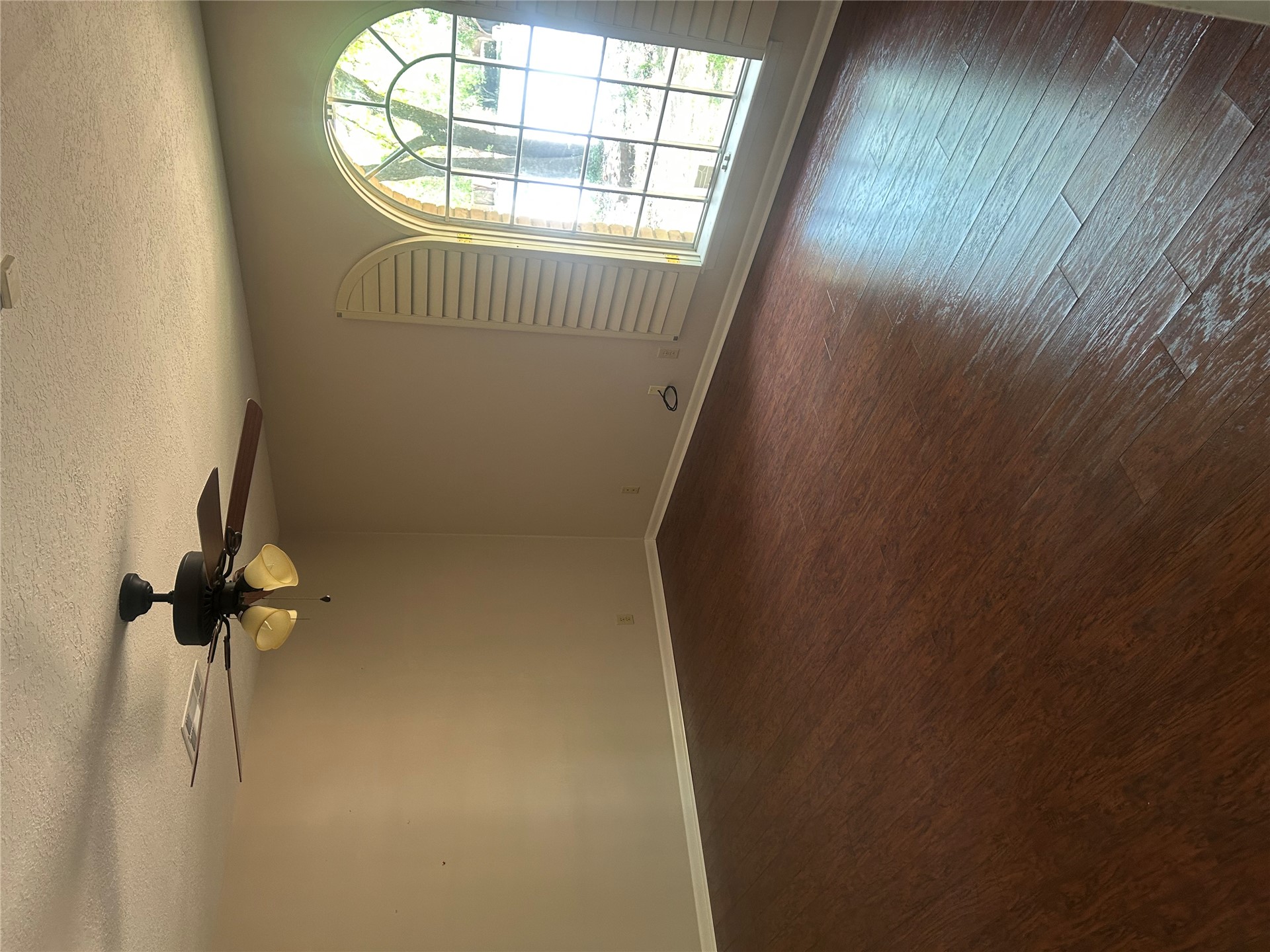 2913 Springdale Lane Duncan, OK 73533 - Photo 30 of 32 Wood-finish flooring, arched window with a white frame, ceiling fan with integrated lighting, and white baseboards