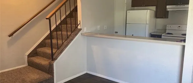 a view of staircase with wooden floor and electronic appliances