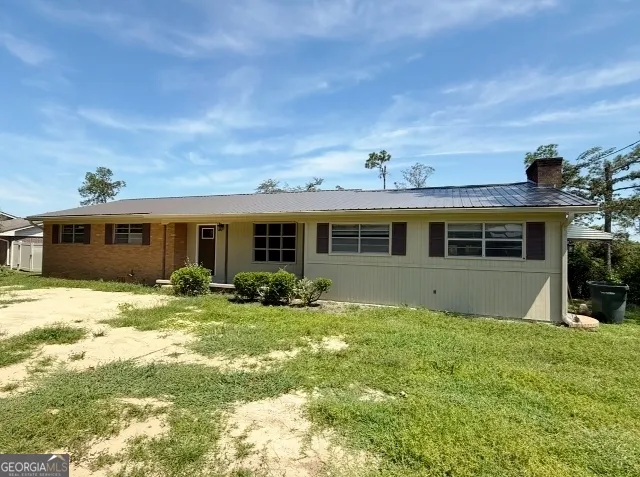 a view of a house with a yard and sitting area