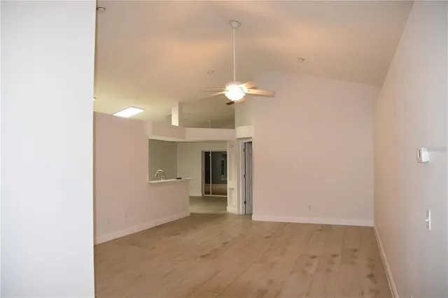 a view of a room with a chandelier fan and refrigerator