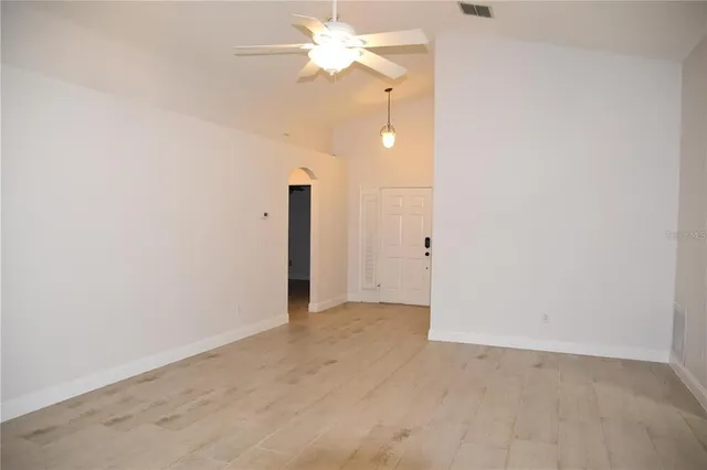 an empty room with a ceiling fan and a window