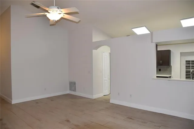 an empty room with a fan & a window