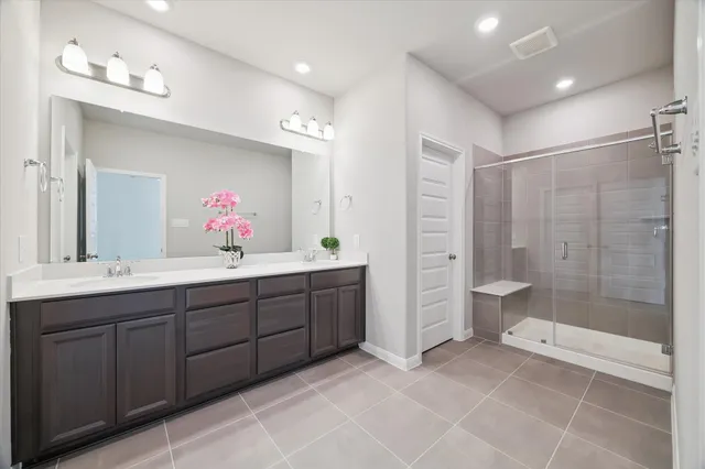 a bathroom with a double vanity sink mirror and shower