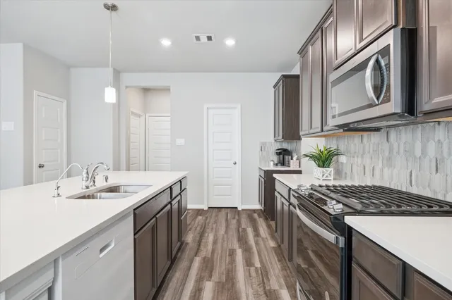 a kitchen with stainless steel appliances granite countertop a sink stove and cabinets