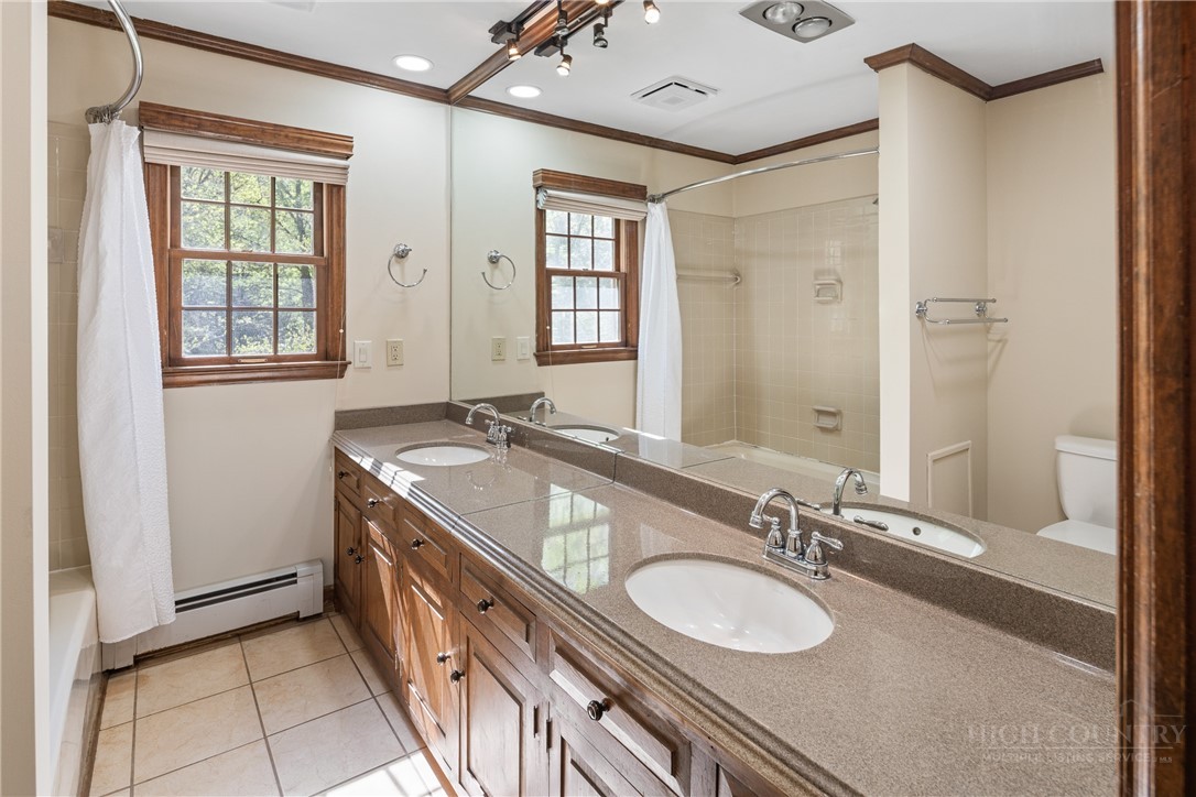 239 Eagle Drive Boone, NC 28607 - Photo 18 of 41 a bathroom with a granite countertop double vanity sink a mirror and a shower