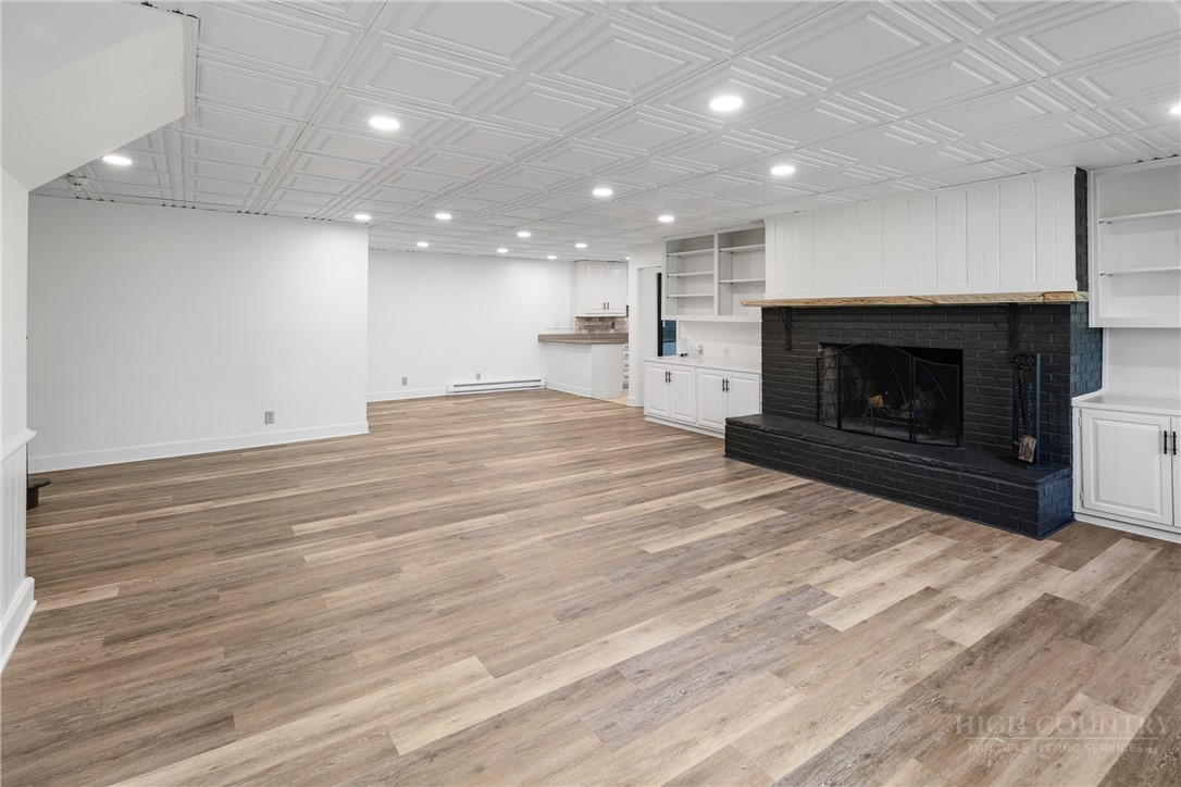 239 Eagle Drive Boone, NC 28607 - Photo 23 of 41 an empty room with wooden floor fireplace and windows