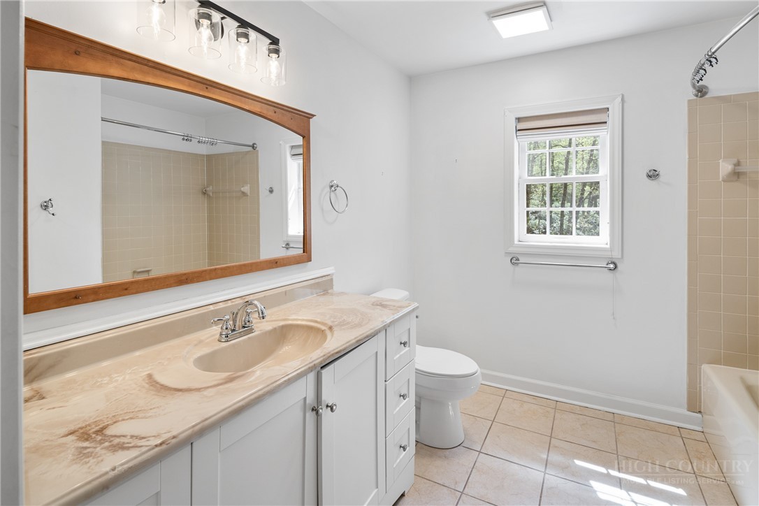 239 Eagle Drive Boone, NC 28607 - Photo 27 of 41 a bathroom with a granite countertop sink a toilet and a mirror