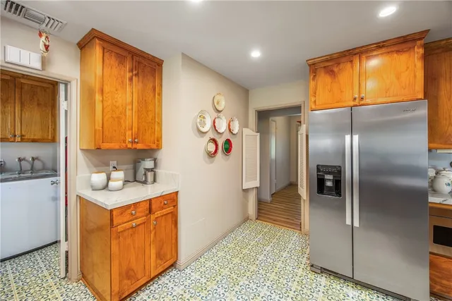 a kitchen with stainless steel appliances granite countertop a refrigerator a stove and a sink
