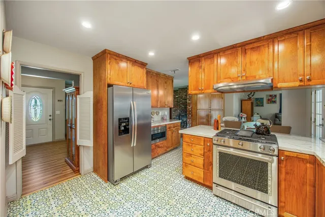 a kitchen with stainless steel appliances granite countertop a stove a refrigerator and a stove