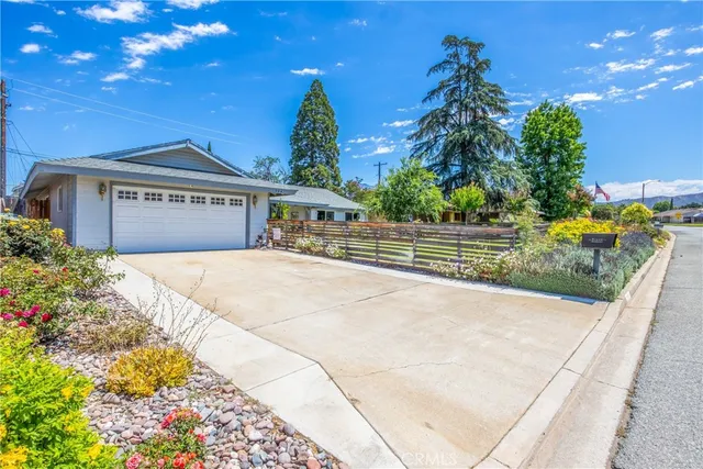 a front view of a house with a yard and trees