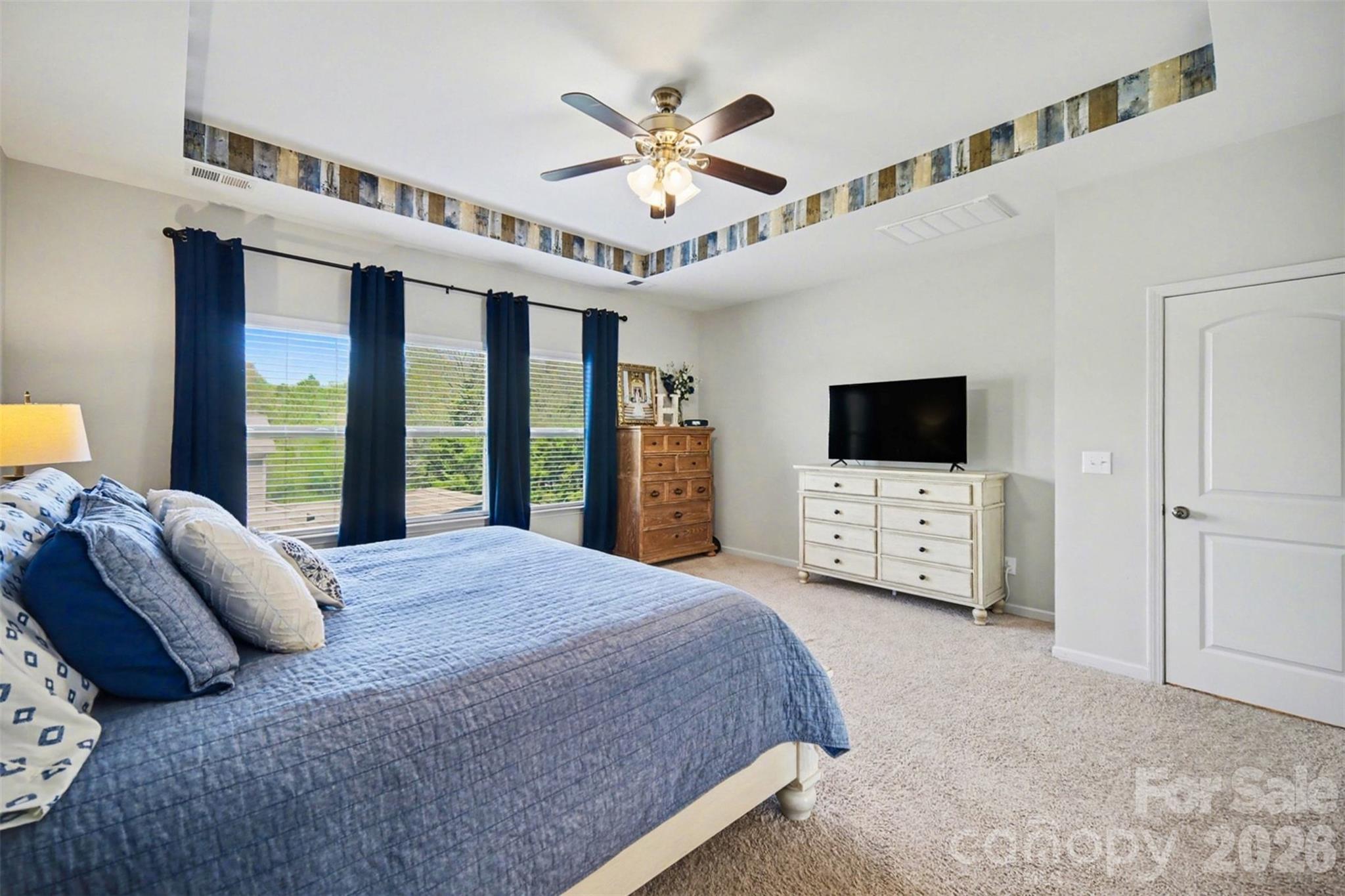 514 Tack Lane Midland, NC 28107 - Photo 23 of 48 a spacious bedroom with a bed and a flat screen tv