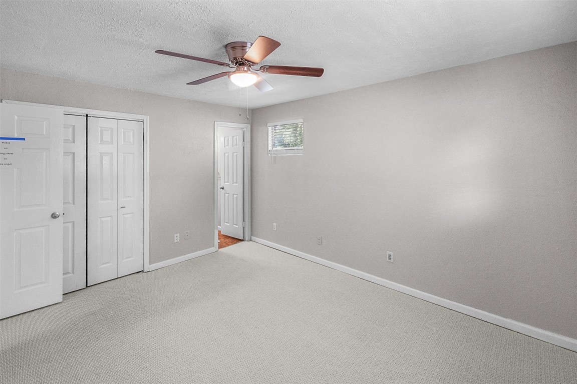 16766 Lake Circle Conroe, TX 77302 - Photo 13 of 22 an empty room with a chandelier fan and windows