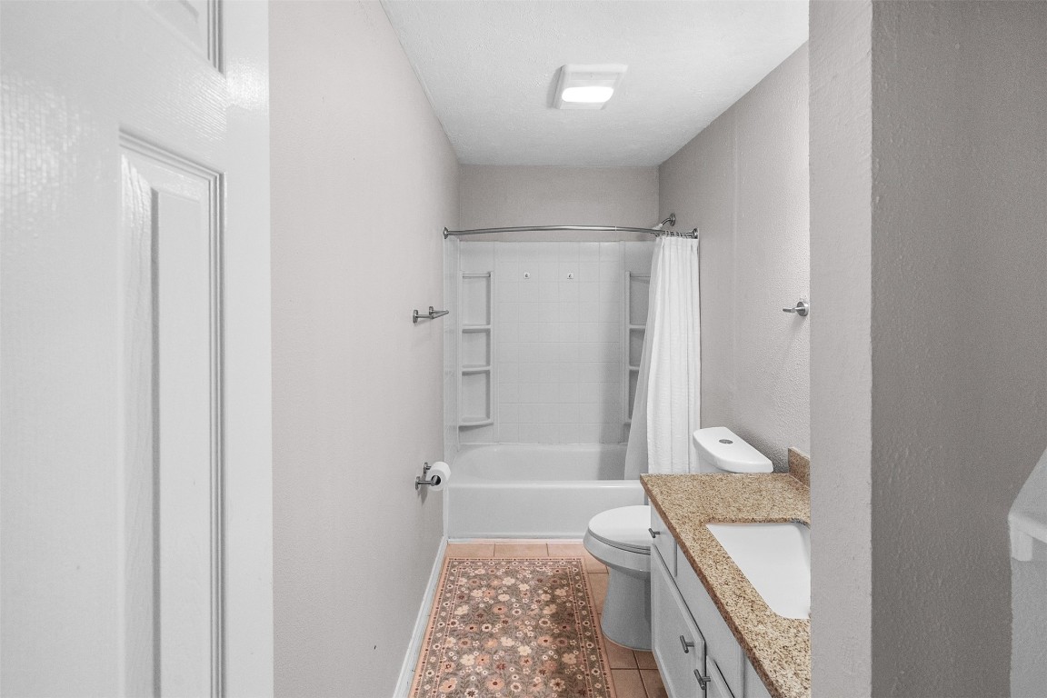 16766 Lake Circle Conroe, TX 77302 - Photo 16 of 22 a bathroom with a granite countertop sink a toilet and shower