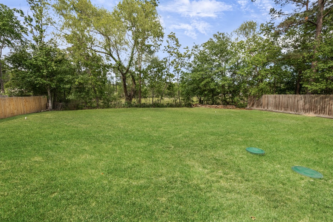 16766 Lake Circle Conroe, TX 77302 - Photo 22 of 22 a view of a grassy field with trees in the background
