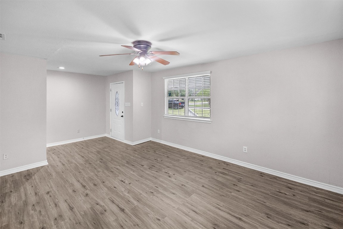 16766 Lake Circle Conroe, TX 77302 - Photo 5 of 22 an empty room with wooden floor fan and windows