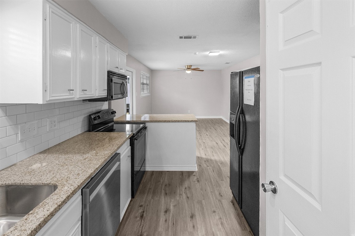 16766 Lake Circle Conroe, TX 77302 - Photo 10 of 22 a kitchen with granite countertop a sink stove and refrigerator