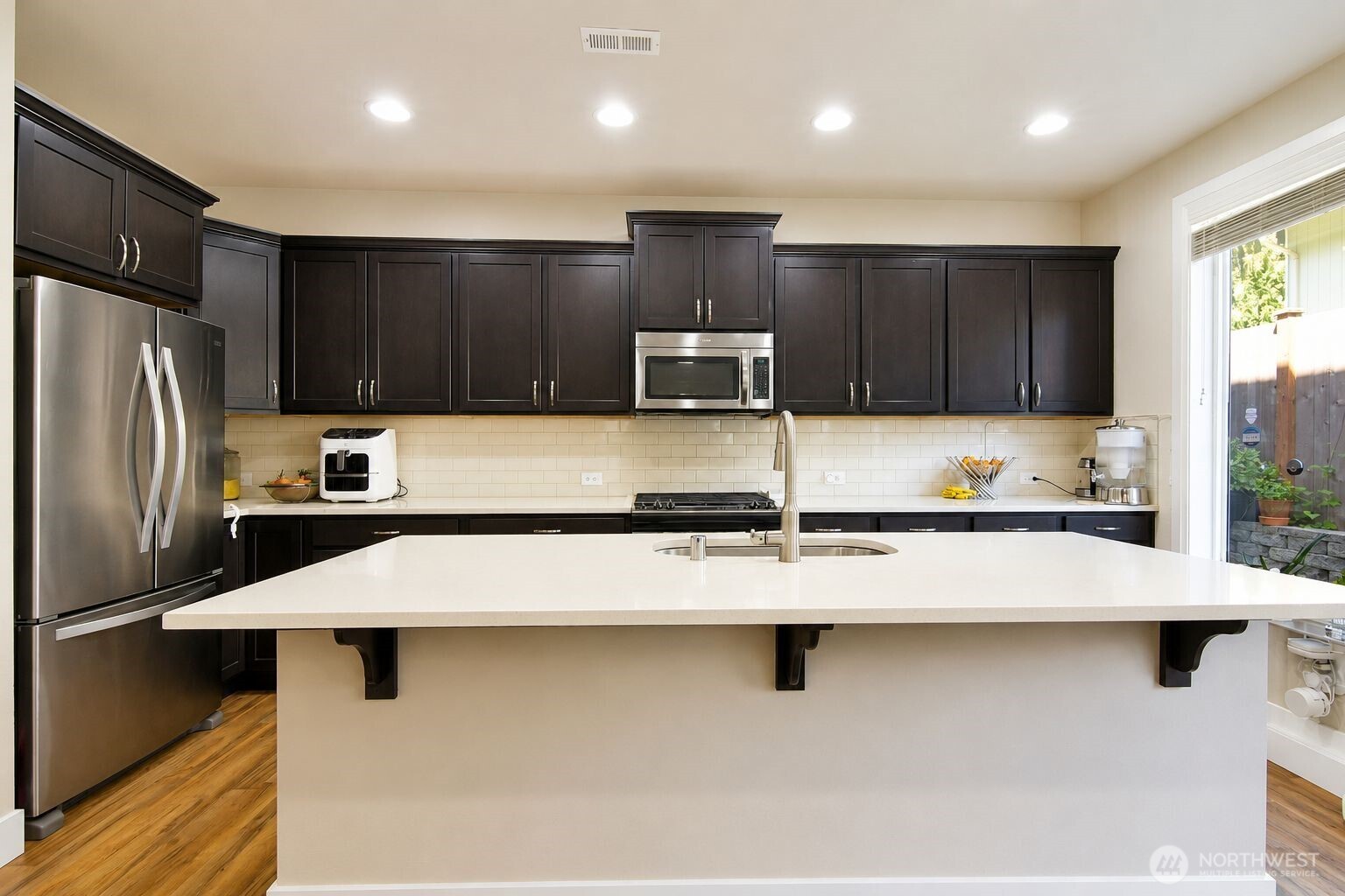 19607 25th Drive Southeast Bothell, WA 98012 - Photo 5 of 30 a kitchen with stainless steel appliances granite countertop a sink wooden cabinets and a refrigerator