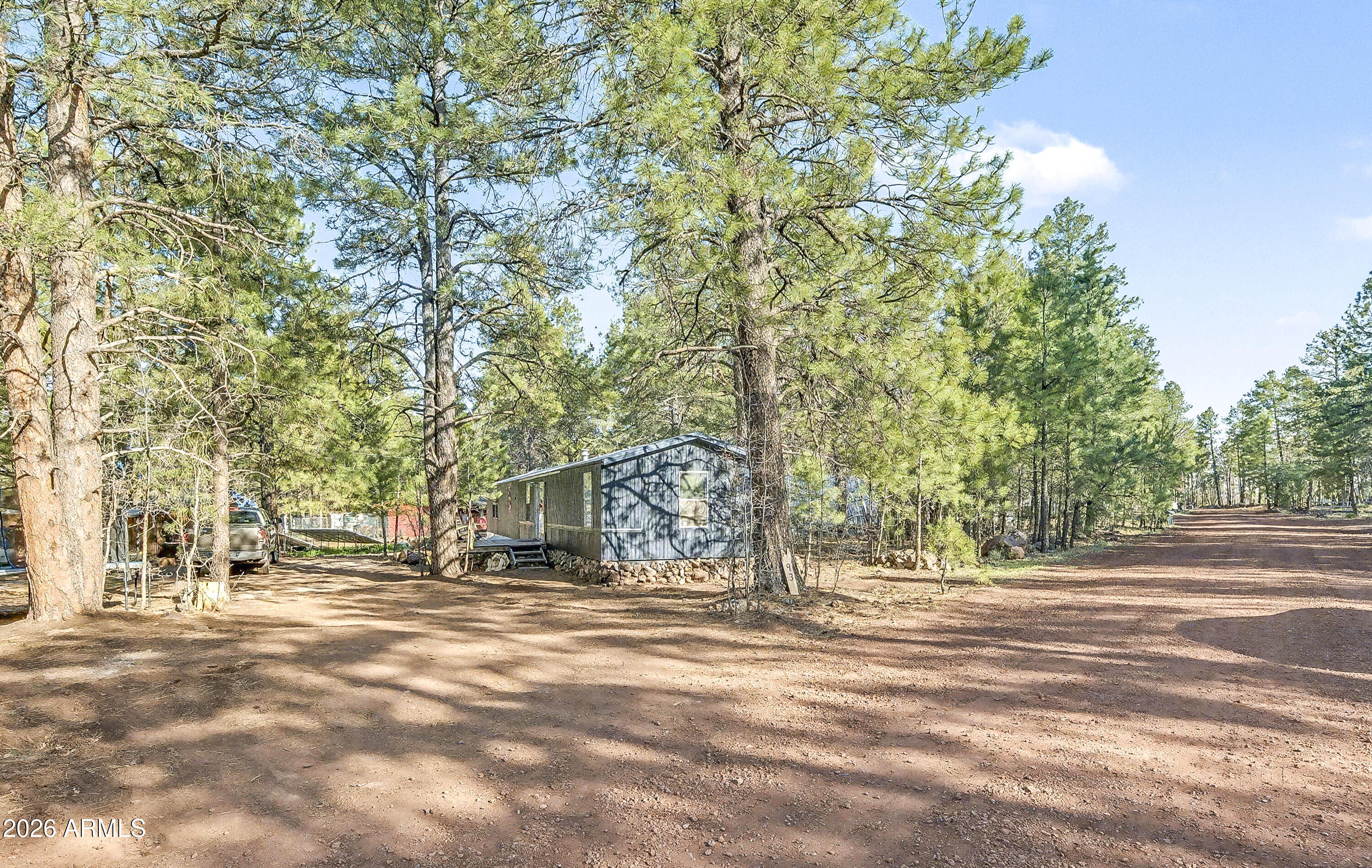 93 Erickson Street Parks, AZ 86005 - Photo 14 of 32 a front view of a house with a yard and trees