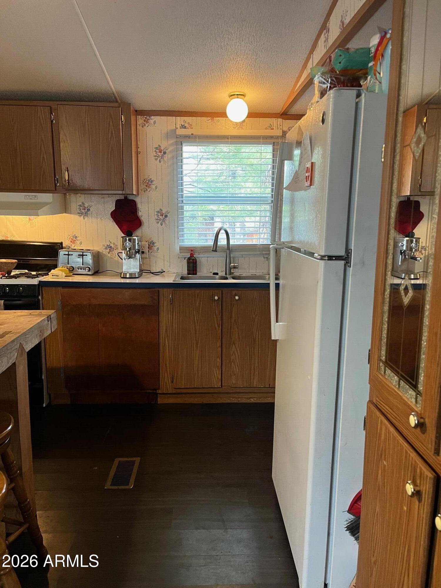 93 Erickson Street Parks, AZ 86005 - Photo 9 of 32 a kitchen with a sink a refrigerator and window
