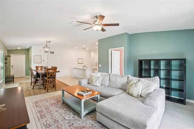 a living room with furniture a rug and a ceiling fan