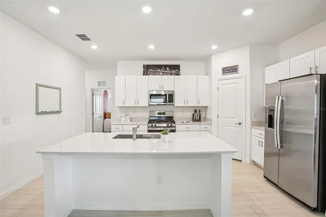 a kitchen with a sink stove top oven and refrigerator
