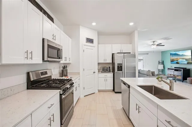 a kitchen with stainless steel appliances a sink a stove top oven a counter space and cabinets