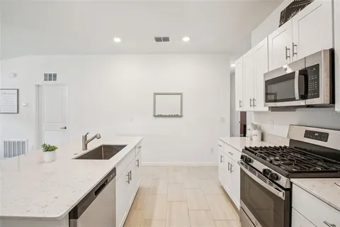 a kitchen with white cabinets and stainless steel appliances