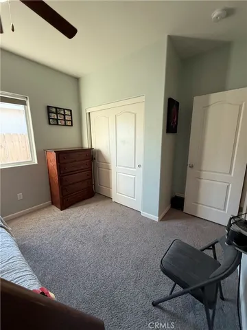 a living room with furniture and a refrigerator