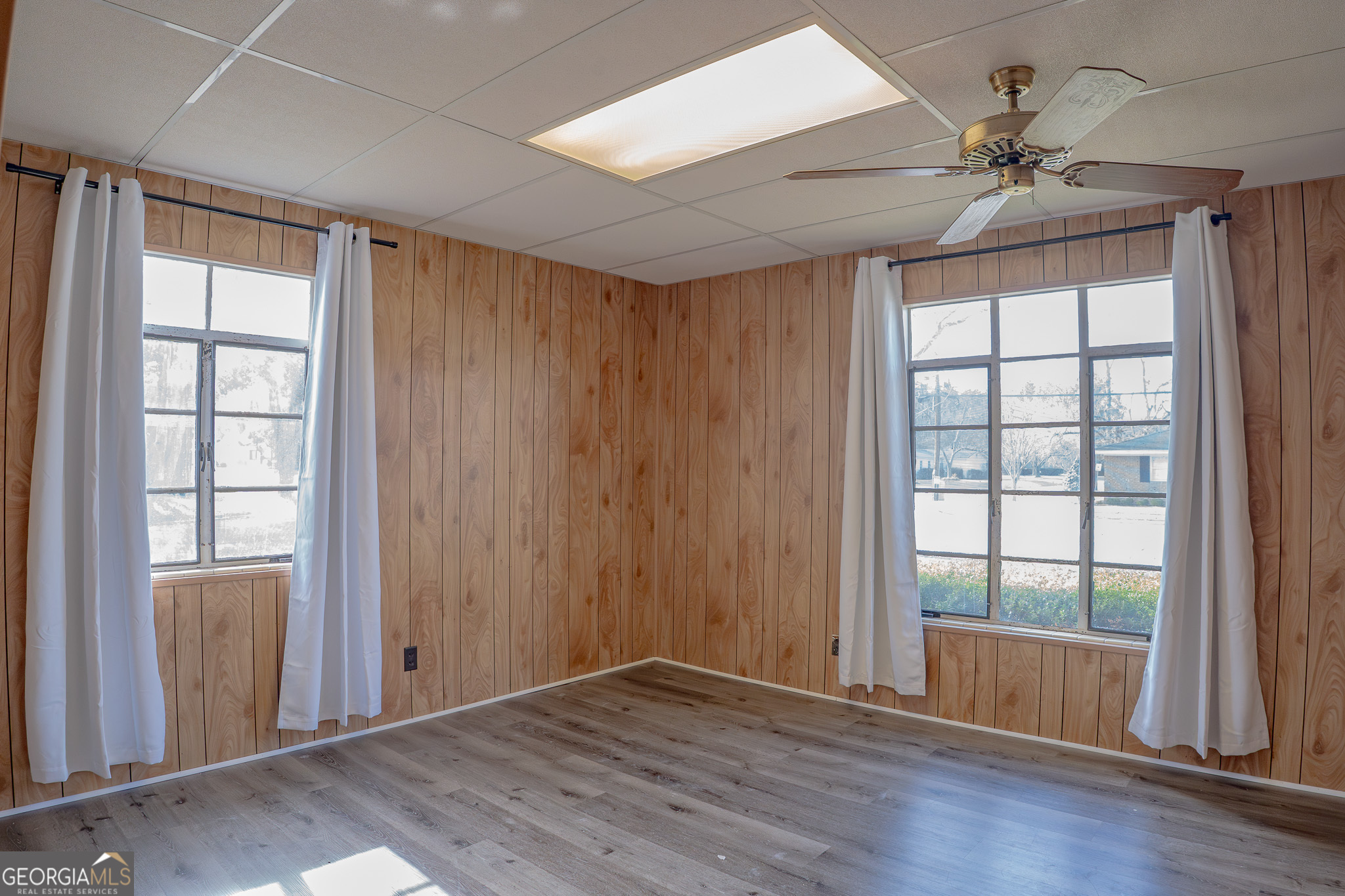 1615 Brunel Street Waycross, GA 31501 - Photo 12 of 28 an empty room with wooden floor fan and windows
