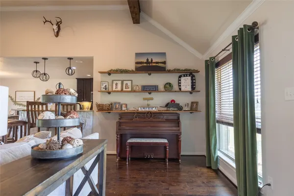 a kitchen with stainless steel appliances kitchen island granite countertop a table chairs and a refrigerator