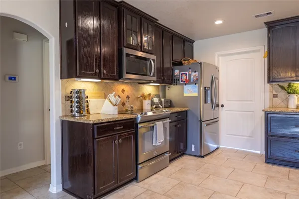 a kitchen with granite countertop a stove and a microwave