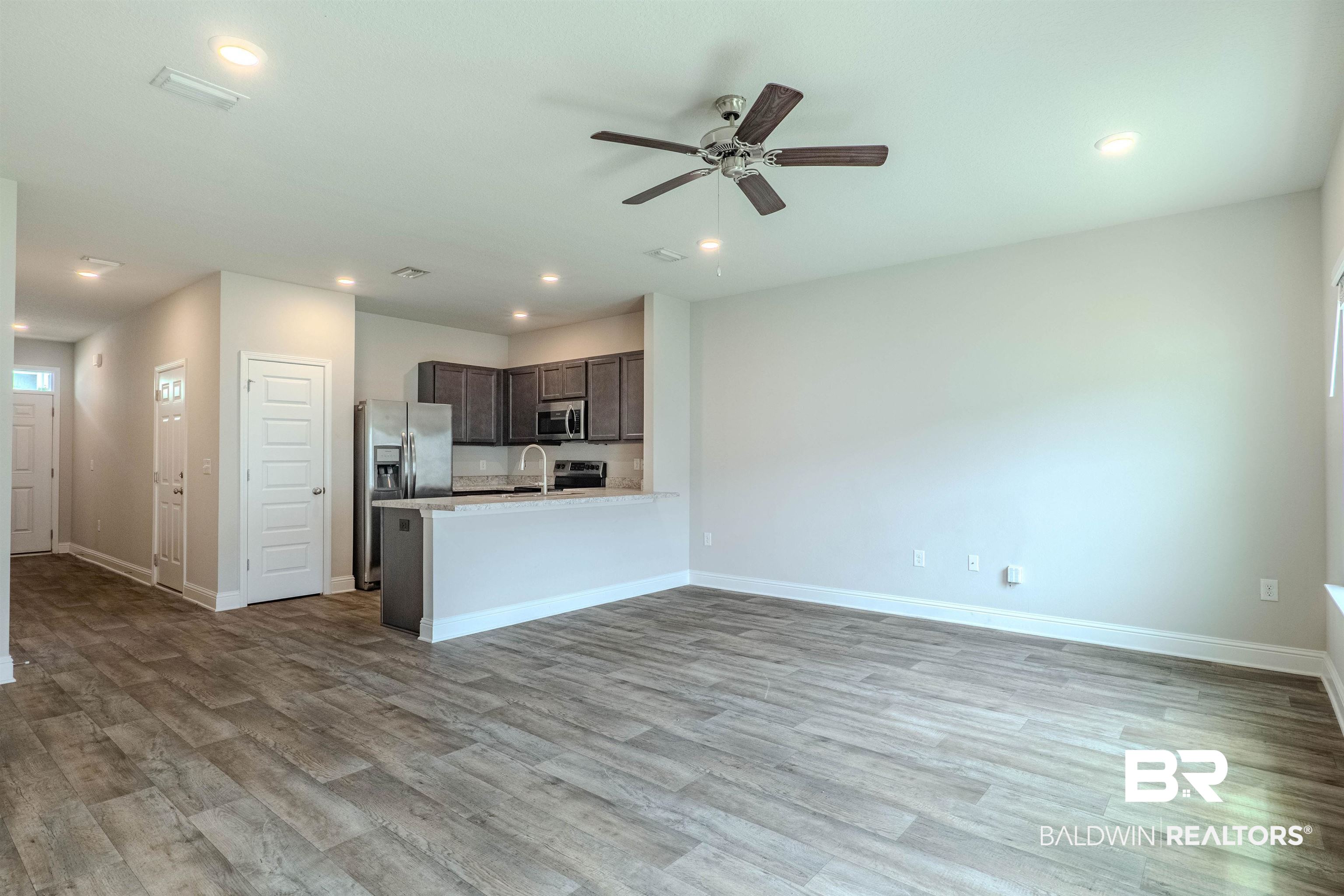 25806 Pollard Road, Unit 32 Daphne, AL 36526 - Photo 4 of 23 Kitchen with light hardwood / wood-style floors, kitchen peninsula, appliances with stainless steel finishes, dark brown cabinetry, and ceiling fan