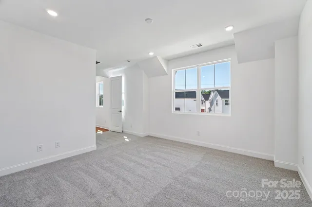 an empty room with cabinet and mirrors