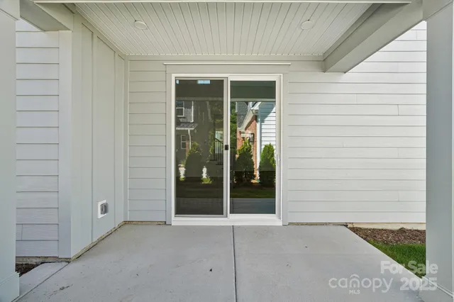 a view of a house with a glass door and wooden floor