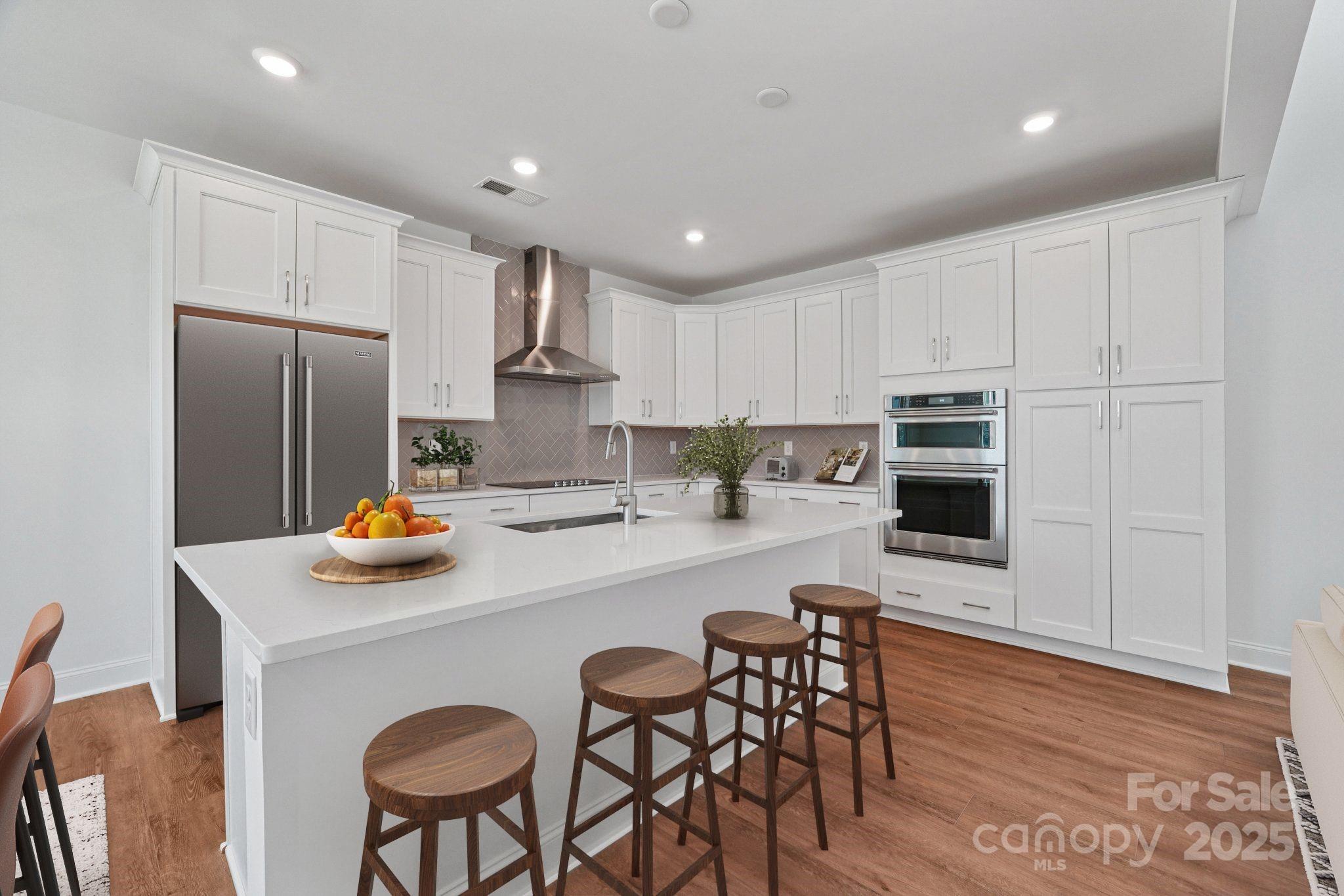 609 Mercury Drive Tega Cay, SC 29708 - Photo 5 of 15 a kitchen with stainless steel appliances granite countertop a sink a stove a refrigerator cabinets and chairs