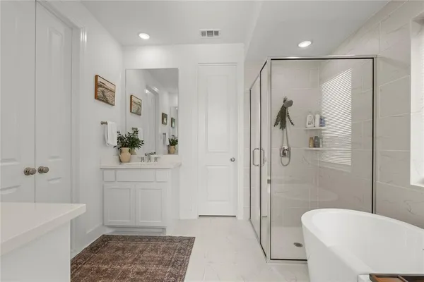 a bathroom with a tub a sink and a shower